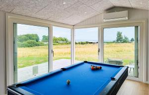 a pool table in a room with a large window at Lovely Home In Haderslev With Sauna in Haderslev +18 photos