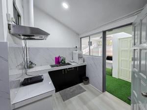 a white kitchen with a sink and a window at VV Homestay in Tawau