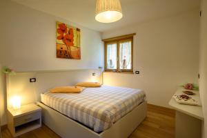 a bedroom with a bed in a room with a window at Le Case del Ponte in Villa di Tirano