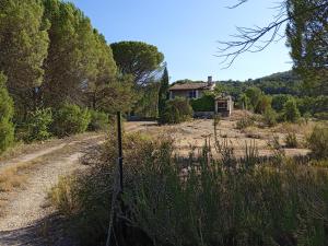 a fence in front of a house on a dirt road at Charmant maset provençal in Montmeyan