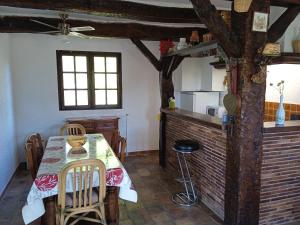 a dining room with a table and a kitchen at Charmant maset provençal in Montmeyan