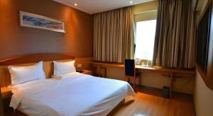 a bedroom with a white bed and a desk and a window at 7 Days Premium Zunyi Conference Site Dingzikou in Zunyi