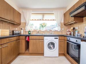 a kitchen with a washer and dryer at Black Rock Cottage in Culbokie +10 photos