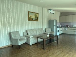 a living room with a couch and a table and a chair at Bright Guesthouse in the center of Yerevan! in Yerevan