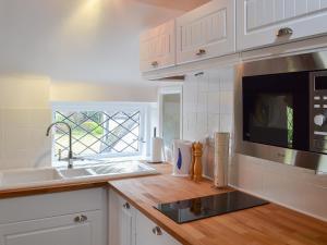 a kitchen with a sink and a microwave at The Beehive in Betley