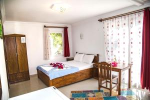 a bedroom with a bed and a table and a window at Flower Hotel Patara in Patara