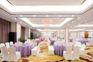 a banquet hall with purple tables and white chairs at Expo Garden Hotel in Kunming +282 photos