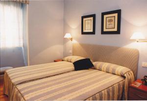 a bedroom with a bed and two pictures on the wall at Torre Ercilla Ostatua in Bermeo