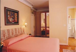 um quarto com uma cama com um cobertor rosa em Torre Ercilla Ostatua em Bermeo