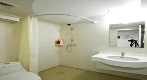 a bathroom with a sink and a toilet and a mirror at Shanghai Blue Mountain Bund Youth Hostel in Shanghai +167 photos