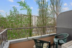 ザグレブにあるClose to the Main Bus Station - cozy and modern private rooms Elena with shared areasの椅子2脚と建物の景色が見えるバルコニー