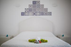 a bedroom with a white bed with a blue and white wall at Punta Sallustro Lipari in Lipari