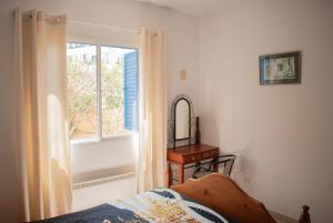 a bedroom with a window and a bed and a mirror at Kings Apartment with private Garden in Paphos City +49 photos
