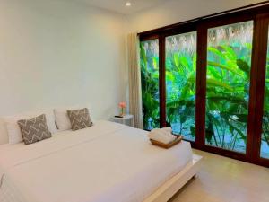 a bedroom with a white bed and a large window at The bora bora - Bed and Dream เดอะ โบรา โบร่า - เบด แอนด์ ดรีม in Ban Chek +63 photos