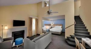 a hotel room with a bed and a living room at Chicago - Lombard in Highland Hills