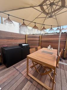 a dining room with a table and a refrigerator at Cocon avec jacuzzi in Périgny