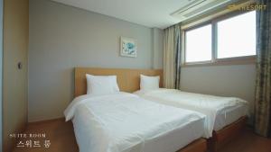 two beds in a bedroom with a window at STX Resort in Mungyeong