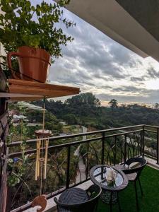 een balkon met stoelen en een tafel met uitzicht bij The Retreat Mountain & Sunrise view Hilltop Hotel Apartment in Cameron Highlands in Cameron Highlands