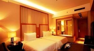 une chambre d'hôtel avec deux lits et un miroir dans l'établissement Ramada Plaza by Wyndham Yangzhou Casa, à Yangzhou