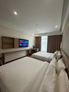 a hotel room with two beds and a flat screen tv at The MAJULAN Hotel in Kota Kinabalu +34 photos
