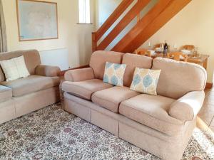 a living room with a couch and a chair at Beck Cottage in Ennerdale Bridge