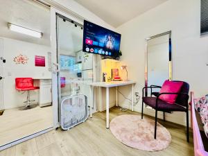 a room with a table and a chair and a tv at Cozy 1 Bedroom Apartment 10 minutes to SeaTac Airport in Seattle