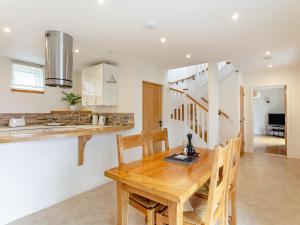 een keuken en eetkamer met een houten tafel bij Rose Cottage - Uk39245 in Inverness