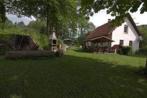 ein großes weißes Haus mit einem Baumstamm im Hof in der Unterkunft Orange House in Kladenské Rovné