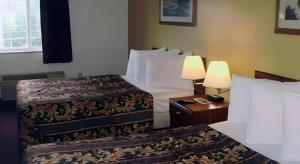 a hotel room with two beds and a table with lamps at Rodeway Inn Salina North in Salina