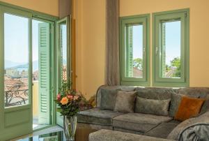 a living room with a couch and windows at Grypes Deluxe Complex in Egina +47 photos