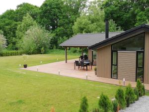 una terraza de madera con cenador en un jardín en Charming Cottage In Fjellerup With Indoor Spa, en Glesborg