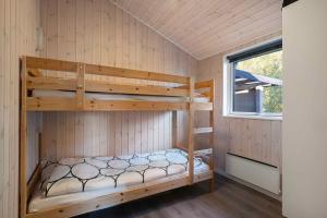 Un dormitorio con dos literas y una ventana. en Charming Cottage In Fjellerup With Indoor Spa, en Glesborg