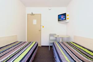 Postel nebo postele na pokoji v ubytování Hôtel Enzo GREEN "Coudes,Issoire,Clermont"