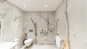 a bathroom with a shower and a toilet and a sink at Alpin Royal in Schaan +20 photos