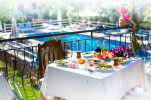 a white table with food and wine on a balcony at Flower Hotel Patara in Patara
