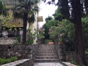 a set of stairs in a garden with trees and flowers at Guesthouse Galimar in Crikvenica