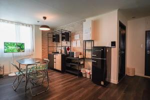 a kitchen with a table and a black refrigerator at 광안해변家 #Gwangan Beach House in Busan