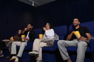 a group of people sitting on a blue couch with drinks at Shada Hotel Dubai - فندق شدا دبي in Dubai