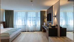 a bedroom with a bed and some windows at Alpin Royal in Schaan