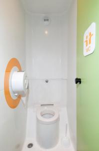 La salle de bains est pourvue de toilettes et d'un rouleau de papier toilette. dans l'établissement Lemon Hôtel Coudes, à Coudes