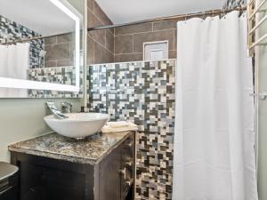 a bathroom with a sink and a shower at Contemporary Lux Pad Patio in Alexandria +19 photos