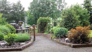 uma passarela de tijolos num jardim com plantas em Ferienwohnung Klinkhammer em Ripsdorf