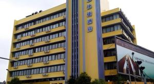 a large yellow building with clocks on the side of it at Home Inn Kunming Baita Road in Kunming