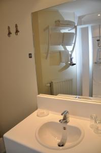 a bathroom with a sink and a mirror at Hotel Bilderdijk in De Haan