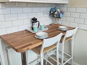 ein Küchentisch mit Stühlen und einem Tischastery ... in der Unterkunft Honeysuckle Cottage in Luncarty + 5 Fotos