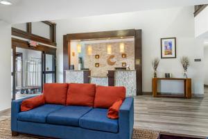 a living room with a blue couch with orange pillows at Comfort Inn & Suites Houston FM1960 - Champions in Houston