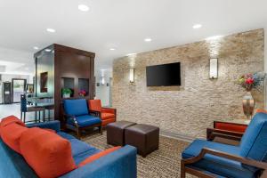 a living room with blue furniture and a stone wall at Comfort Inn & Suites Houston FM1960 - Champions in Houston
