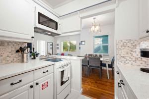 a kitchen with white cabinets and a dining room at Condo by the Beach King Beds Lush Patio w BBQ Breakers Key One H0MES in Fort Lauderdale