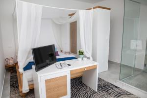 a white room with a desk with a tv on it at Hotel Casa del Mare - Blanche in Herceg-Novi