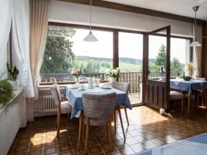a dining room with two tables and a large window at Pension Haus Brieden in Winterberg